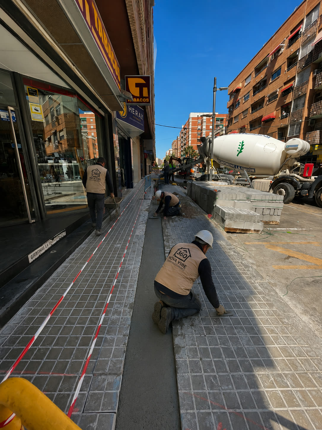 Pavimentación de acera con camión hormigonera en calle de Valencia